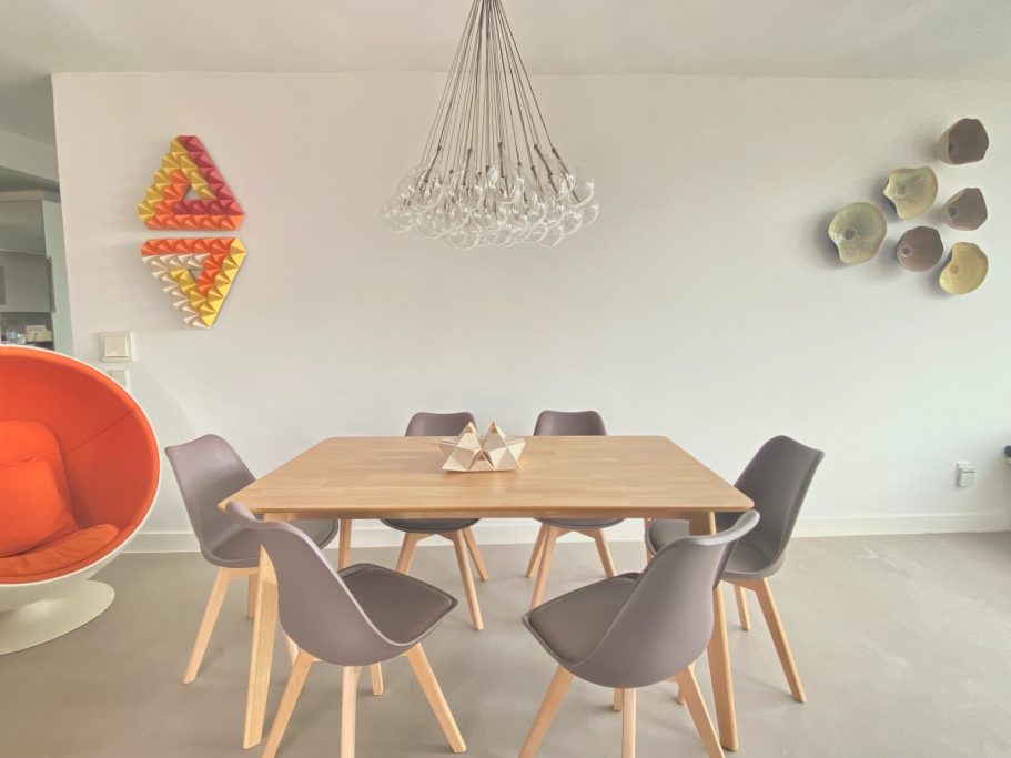 Piso Turístico de Lujo en Benalmádena: Comedor Elegante con Ball Chair y Arte Contemporáneo